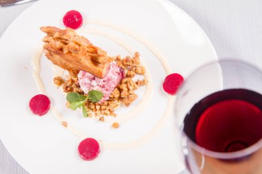 Lehçe-Litvanyaca geleneksel bir restoranda taze nane ile dekore edilmiş dondurma, kavrulmuş fındık ve ahududulu jöle ile pasta ('ağaç kek') - sekacz (Polonya) veya sakotis (Litvanyaca) tükürmek