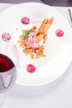 Lehçe-Litvanyaca geleneksel bir restoranda taze nane ile dekore edilmiş dondurma, kavrulmuş fındık ve ahududulu jöle ile pasta ('ağaç kek') - sekacz (Polonya) veya sakotis (Litvanyaca) tükürmek