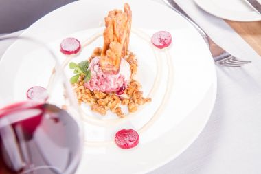 Lehçe-Litvanyaca geleneksel bir restoranda taze nane ile dekore edilmiş dondurma, kavrulmuş fındık ve ahududulu jöle ile pasta ('ağaç kek') - sekacz (Polonya) veya sakotis (Litvanyaca) tükürmek