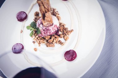 Lehçe-Litvanyaca geleneksel bir restoranda taze nane ile dekore edilmiş dondurma, kavrulmuş fındık ve ahududulu jöle ile pasta ('ağaç kek') - sekacz (Polonya) veya sakotis (Litvanyaca) tükürmek