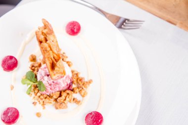 Lehçe-Litvanyaca geleneksel bir restoranda taze nane ile dekore edilmiş dondurma, kavrulmuş fındık ve ahududulu jöle ile pasta ('ağaç kek') - sekacz (Polonya) veya sakotis (Litvanyaca) tükürmek