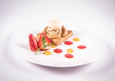 Bir çilek, meyve sosu ve bitki beyaz zemin üzerine elmalı pasta dondurma ile süslenmiş