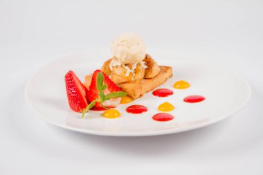 Bir çilek, meyve sosu ve bitki beyaz zemin üzerine elmalı pasta dondurma ile süslenmiş