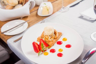 Elmalı turta dondurma çilek ile dekore edilmiş meyve sosu ve bitki bir restoranda servis