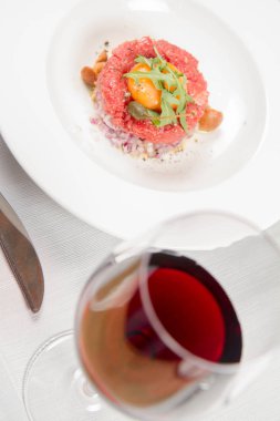 Steak tartare bir restoranda yumurta sarısı, soğan, Kapari, mantar ve roket salata ile servis
