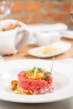 Steak tartare bir restoranda yumurta sarısı, soğan, Kapari, mantar ve roket salata ile servis