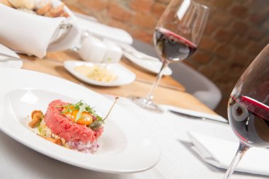 Steak tartare bir restoranda yumurta sarısı, soğan, Kapari, mantar ve roket salata ile servis