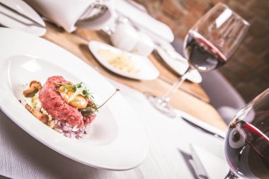 Steak tartare bir restoranda yumurta sarısı, soğan, Kapari, mantar ve roket salata ile servis