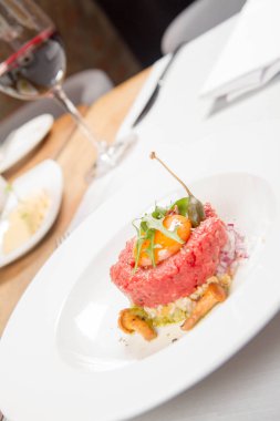 Steak tartare bir restoranda yumurta sarısı, soğan, Kapari, mantar ve roket salata ile servis