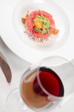 Steak tartare bir restoranda yumurta sarısı, soğan, Kapari, mantar ve roket salata ile servis