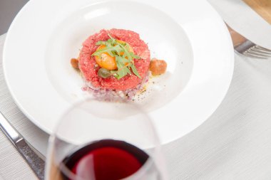 Steak tartare bir restoranda yumurta sarısı, soğan, Kapari, mantar ve roket salata ile servis