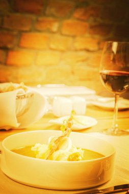 Bıldırcın yumurta, ekşi krema, patates püresi ve gevrek domuz pastırması ile kuzukulağı ve yeşil sebze çorbası Krem bir restoranda servis