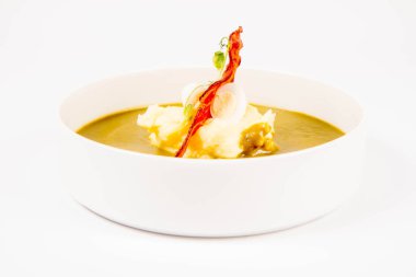 Bıldırcın yumurta, ekşi krema, patates püresi ve beyaz zemin üzerine gevrek domuz pastırması ile kuzukulağı ve yeşil sebze çorbası Krem