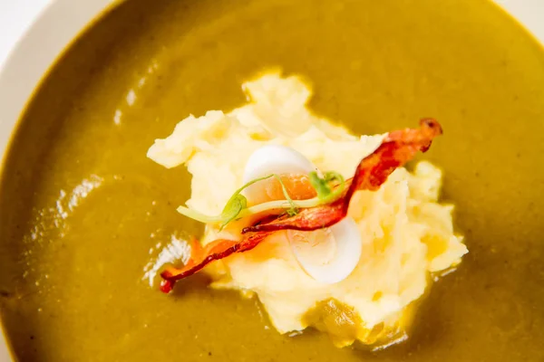 Cream of sorrel and green vegetables soup with quail egg, sour cream, mashed potatoes and crispy bacon on a white background — Stock Image Cream Sorrel Green Vegetables Soup Quail Egg Sour Cream Mashed Stock Picture