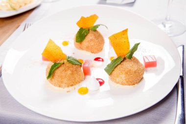 Bir restoranda Erik köfte tarçın, beyaz çikolata ve vanilya sosu ile servis