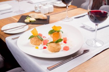 Bir restoranda Erik köfte tarçın, beyaz çikolata ve vanilya sosu ile servis