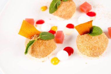 Erik köfte tarçın, beyaz çikolata ve beyaz zemin üzerine vanilya sosu ile