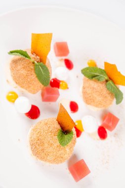 Erik köfte tarçın, beyaz çikolata ve beyaz zemin üzerine vanilya sosu ile