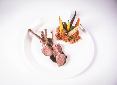 Kuzu pirzolası, kızarmış mercimek ile nane, beyaz bir arka plan üzerinde kızartma sebze ve biberiye sos