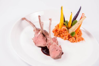 Kuzu pirzolası, kızarmış mercimek ile nane, beyaz bir arka plan üzerinde kızartma sebze ve biberiye sos