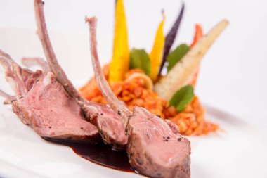 Kuzu pirzolası, kızarmış mercimek ile nane, beyaz bir arka plan üzerinde kızartma sebze ve biberiye sos