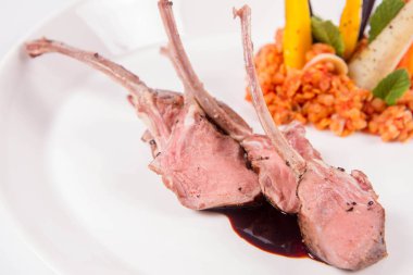 Kuzu pirzolası, kızarmış mercimek ile nane, beyaz bir arka plan üzerinde kızartma sebze ve biberiye sos