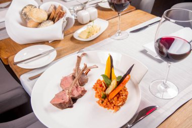 Kuzu pirzolası, kızarmış mercimek nane, kızartma sebze ve bir restoranda servis biberiye sos ile