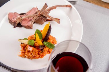 Kuzu pirzolası, kızarmış mercimek nane, kızartma sebze ve bir restoranda servis biberiye sos ile