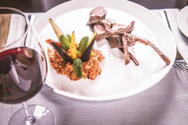 Kuzu pirzolası, kızarmış mercimek nane, kızartma sebze ve bir restoranda servis biberiye sos ile