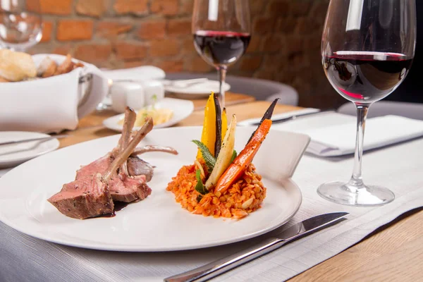 Kuzu pirzolası, kızarmış mercimek nane, kızartma sebze ve bir restoranda servis biberiye sos ile