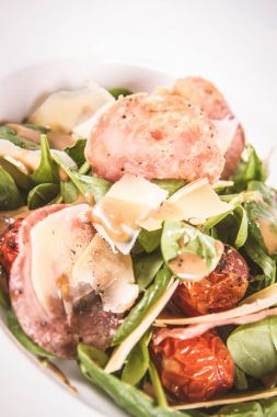 Bebek ıspanak, Kuru sosis, olgunlaştı peynir, kızarmış domates, kekik balsamik salata salata beyaz bir arka plan üzerinde
