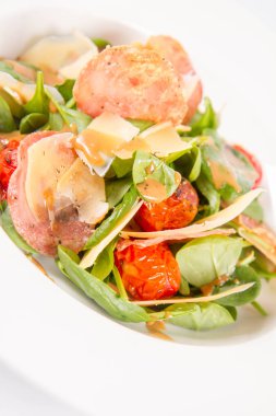 Bebek ıspanak, Kuru sosis, olgunlaştı peynir, kızarmış domates, kekik balsamik salata salata beyaz bir arka plan üzerinde