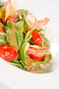 Bebek ıspanak, Kuru sosis, olgunlaştı peynir, kızarmış domates, kekik balsamik salata salata beyaz bir arka plan üzerinde