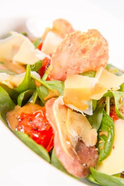 Bebek ıspanak, Kuru sosis, olgunlaştı peynir, kızarmış domates, kekik balsamik salata salata beyaz bir arka plan üzerinde