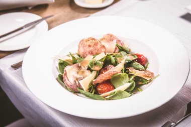 Bebek ıspanak, Kuru sosis, olgunlaştı peynir, kızarmış domates, kekik balsamik salata salata bir restoranda servis