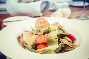 Bebek ıspanak, Kuru sosis, olgunlaştı peynir, kızarmış domates, kekik balsamik salata salata bir restoranda servis