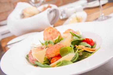 Bebek ıspanak, Kuru sosis, olgunlaştı peynir, kızarmış domates, kekik balsamik salata salata bir restoranda servis