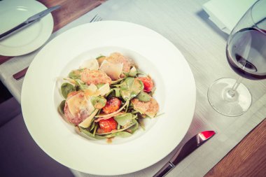 Bebek ıspanak, Kuru sosis, olgunlaştı peynir, kızarmış domates, kekik balsamik salata salata bir restoranda servis