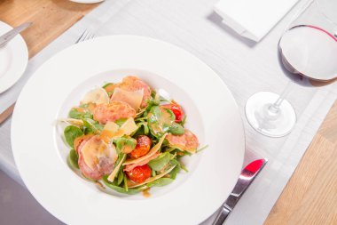 Bebek ıspanak, Kuru sosis, olgunlaştı peynir, kızarmış domates, kekik balsamik salata salata bir restoranda servis