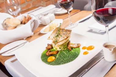 Fried zander, yeşil sebzeler ile darı, kekik üzerindeki bir restoranda servis bazı yumurta sarısı ile yeşil yaprak ile kızarmış çörek