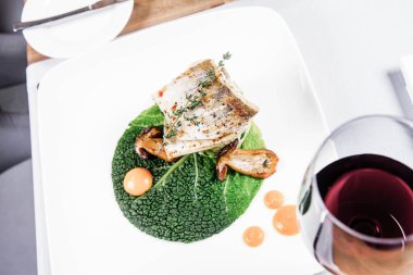 Fried zander, yeşil sebzeler ile darı, kekik üzerindeki bir restoranda servis bazı yumurta sarısı ile yeşil yaprak ile kızarmış çörek