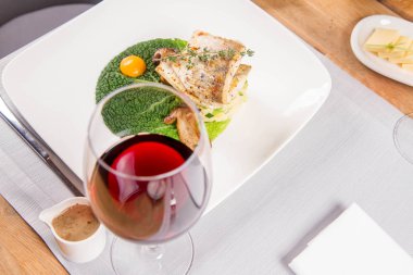 Fried zander, yeşil sebzeler ile darı, kekik üzerindeki bir restoranda servis bazı yumurta sarısı ile yeşil yaprak ile kızarmış çörek