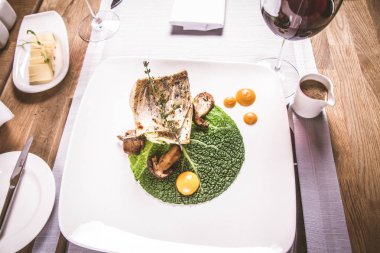 Fried zander, yeşil sebzeler ile darı, kekik üzerindeki bir restoranda servis bazı yumurta sarısı ile yeşil yaprak ile kızarmış çörek