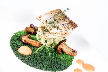 Fried zander, darı yeşil sebzeler ile beyaz bir arka plan üzerinde bazı yumurta sarısı ile üzerindeki yeşil yaprak kekik ile kızarmış çörek