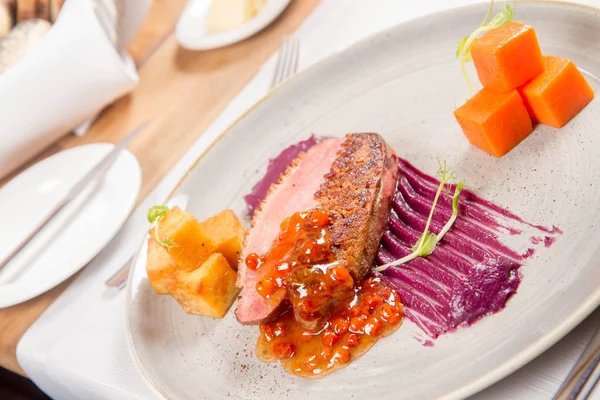 Roast duck breast, red cabbage with apple, roasted potatoes,mountain ash and honey sauce