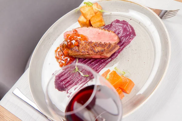 Roast duck breast, red cabbage with apple, roasted potatoes,mountain ash and honey sauce