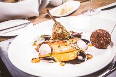 Gine fowl, kabak püresi, kızarmış buğday, sos sos bir restoranda