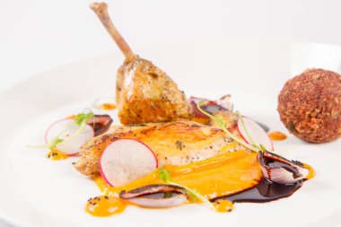 Domuz güveci, kabak püresi, kızarmış buğday, beyaz zemin üzerine et suyu sosu