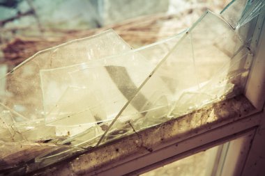 Kırık bir pencere ve cam kırıkları