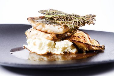 Mersin balığı, savoy lahana, mantar suyu, beyaz bir arka plan üzerinde bir tabakta tereyağlı patates püresi